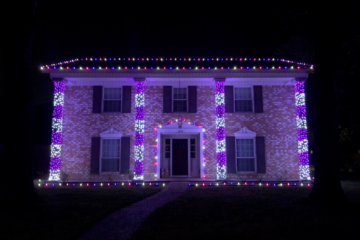 A charming house adorned with pink, purple, and white lights