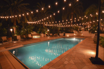 Bistro lights hanging over a pool