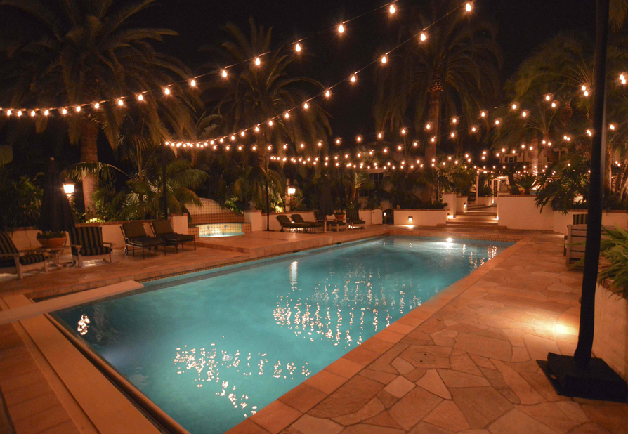 Bistro lights hanging over a pool